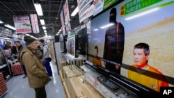 A man watches a television broadcasting news about detained two Japanese, at an electronics store in Tokyo, Jan. 20, 2015. 