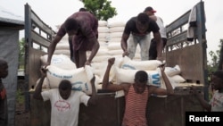 Volunteers unload maize meal supplied by the United Nations Food Program at the Lovua refugee camp in Angola, Sept. 13, 2017. More than 6,000 Congolese have fled to Zambia in the last month.