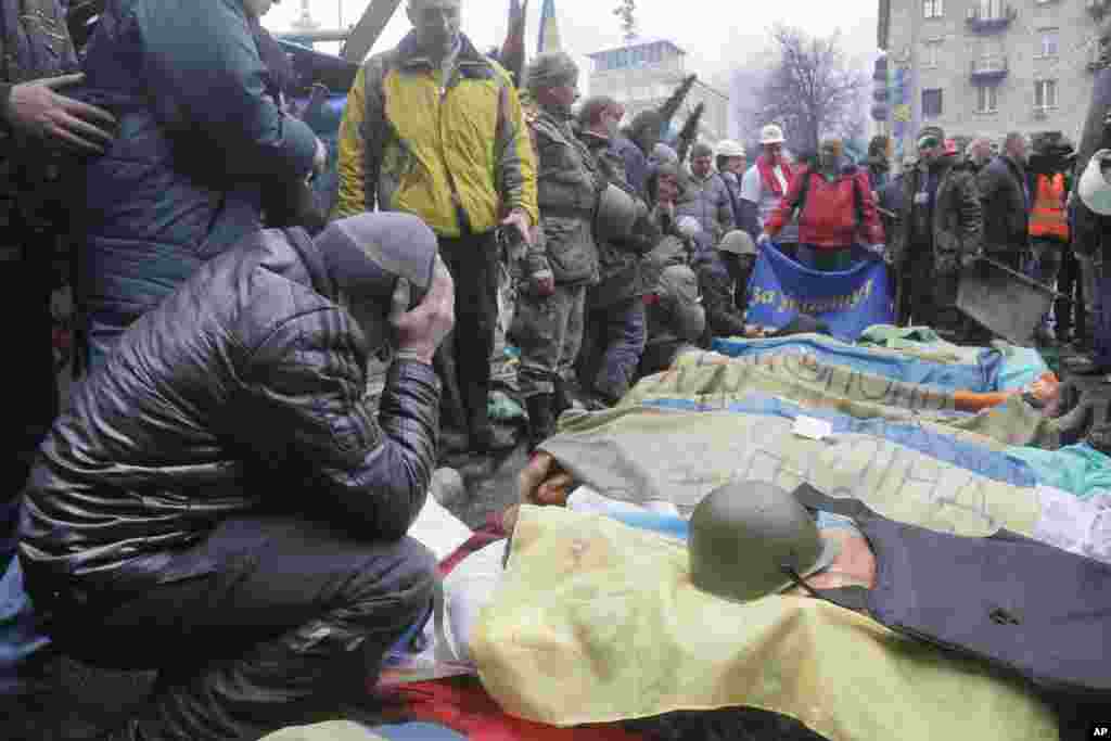 Activists pay respects to anti-government protesters killed in clashes with riot police in Kyiv's Independence Square, Feb. 20, 2014.