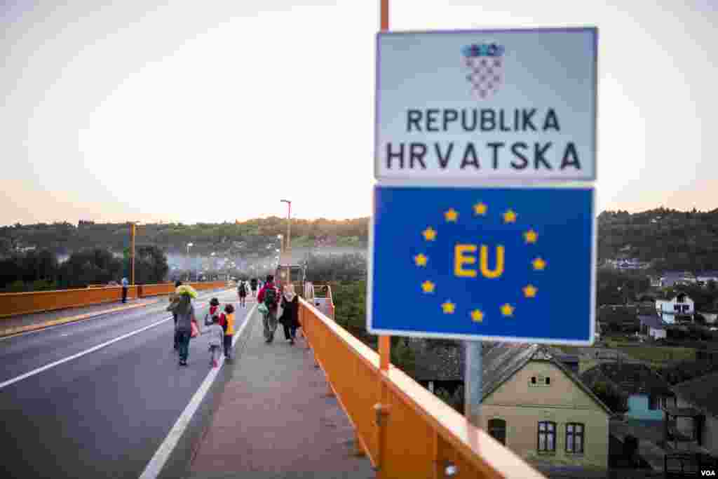 Migrants walk across the bridge over Danube to Croatia, Sept. 17, 2015. (Ayesha Tanzeem/VOA)