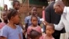 FILE - A health care worker checking for Ebola signs takes the temperatures of children before they enter their school in Conakry, Guinea, Jan. 19, 2015.
