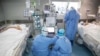 Medical staff treat COVID-19 coronavirus patients at a hospital in Wuhan, in China's central Hubei province, March 19, 2020.