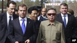 North Korean leader Kim Jong Il, second right, and Russian President Dmitry Medvedev, second left, walk during a meeting an a military garrison, outside Ulan-Ude, August 24, 2011