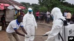 Les médecins nettoient leurs mains après avoir touché du sang d'un enfant testé pour le virus d'ebola à Morovia, Liberia, le 30 juin 2015