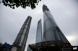 The Shanghai Tower, right, is seen among other skyscrapers prior to the topping off ceremony in Shanghai, China, Saturday, Aug. 3, 2013.