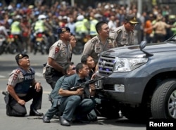 Police officers react near the site of a blast in Jakarta, Indonesia, January 14, 2016. Several explosions went off and gunfire broke out in the centre of the Indonesian capital on Thursday and police said they suspected a suicide bomber was responsible f