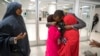 FILE - Ismail Issack, father of Miski Shalle, 11, and Muzamil Shalle, 14, embraces his children as their mother Halima Mohamed, far left, looks on as they reunite for the first time in seven years at John F. Kennedy International Airport in New York.