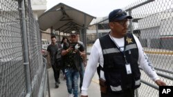 A security guard leads a group of U.S. asylum seekers out of Mexican immigration offices after they were returned by U.S. authorities to wait in Mexico under the so-called Remain in Mexico program, in Ciudad Juarez, Mexico, July 17, 2019.