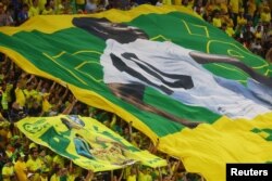 Los fanáticos dentro del estadio en Doha, la capital de Qartar, sostienen una pancarta del ex jugador brasileño Pelé con un mensaje por su pronta mejoría de salud, el 5 de diciembre de 2022.