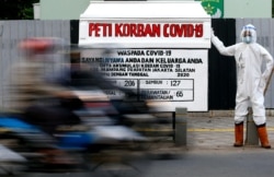 Peti mati dan boneka yang mengenakan pakaian pelindung diri agar terlihat seperti petugas kesehatan terlihat di tempat umum untuk memperingatkan orang-orang tentang bahaya penyakit virus corona (COVID-19) di Jakarta, 18 Agustus 2020. (Foto: REUTERS/Ajeng