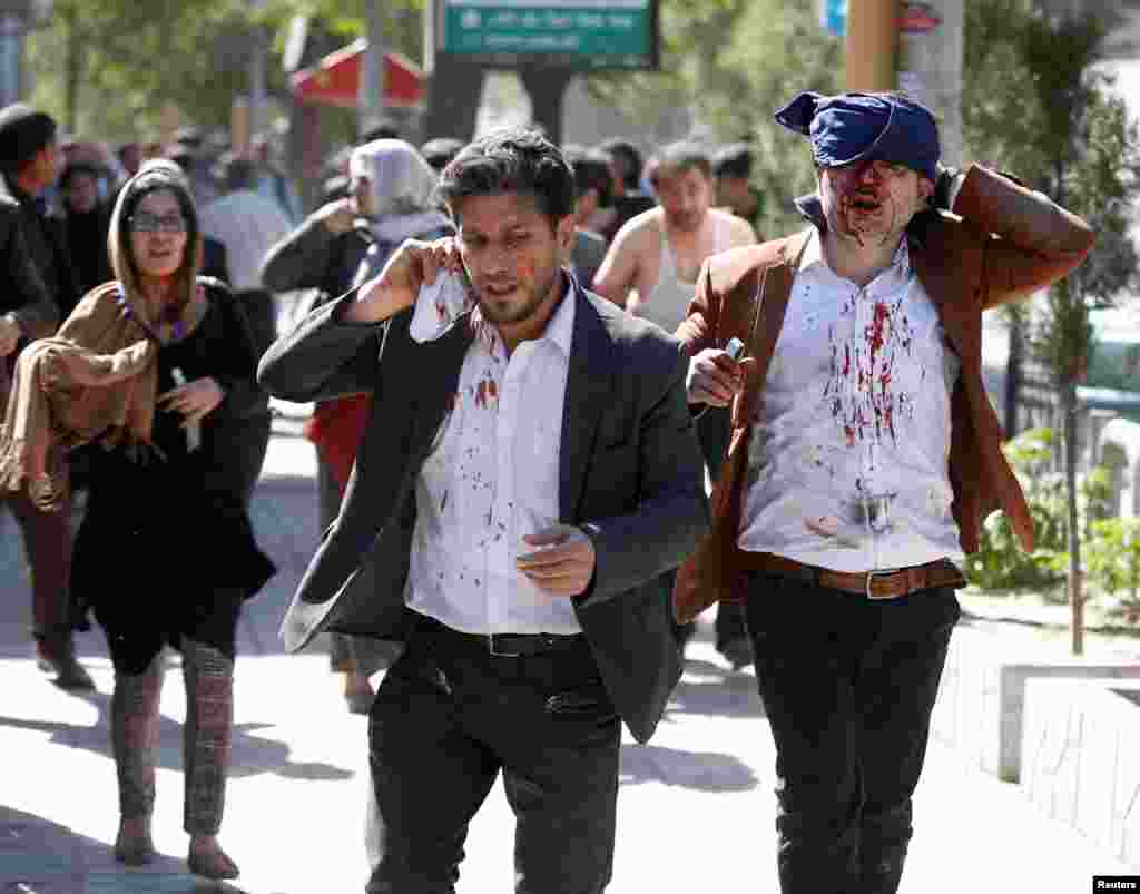 Wani dan kasar Afganistan da ya samu rauni na gujewa wurin da aka kai hair a babban birnin Kabul dake Afghanistan, ranar Laraba 31 ga watan Mayu, shekarar 2017. 
