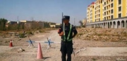FILE - A Chinese police officer takes his position by the road near what is officially called a vocational education center in Yining in Xinjiang Uighur Autonomous Region, China, Sept. 4, 2018.
