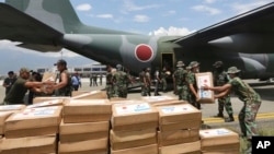 Indonesian and Japanese military personnel unload relief aid from a Japan Air Force cargo plane at the Mutiara Sis Al-Jufri airport in Palu, Central Sulawesi, Indonesia, Oct. 6, 2018.