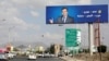 FILE - An image of Lebanese Information Minister George Kordahi is seen on a billboard in Sanaa, Yemen, Oct. 31, 2021. The billboard reads: "Yes, George, Yemen's war is futile."
