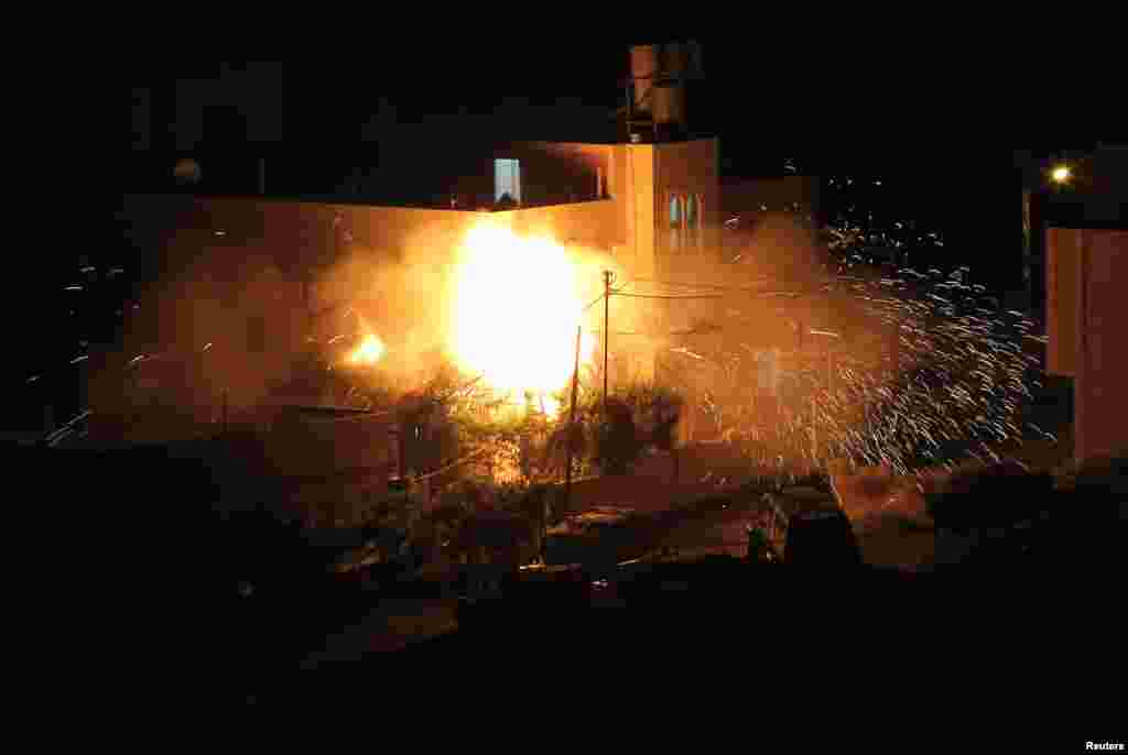 Flames are seen after a blast on the top floor of the family home of an alleged abductor in the West Bank City of Hebron. The bodies of three missing Israeli teenagers were found in the occupied West Bank and Israel vowed to punish Hamas, the Palestinian group it accuses of kidnapping and killing them.