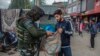 Tentara India tampak mengecek isi tas dari seorang pemuda Kashmir yang berjalan melewati area sibuk di pasar di Srinagar, wilayah Kashmir yang dikontrol oleh India, pada 11 Oktober 2021. (Foto: AP/Mukhtar Khan)