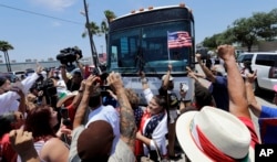 FILE - Demonstrators block a bus with migrant children on board, during a protest outside the U.S. Border Patrol Central Processing Center, in McAllen, Texas, June 23, 2018.