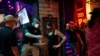 Lindsey Pettita (ketiga dari kiri), manajer bar The Jackalope berbincang dengan petugas pengawas minuman alkohol Texas untuk memeriksa aturan jarak aman untuk meredam penyebaran virus corona (Covid-19), setelah bar buka kembali, di Austin, Texas, 22 Mei 2