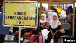 Para TKI menunggu dokumen yang sedang diproses sebelum berangkat ke Arab Saudi di bandara Soekarno-Hatta, Jakarta, 28 Oktober 2009. (Foto: Beawiharta/Reuters).