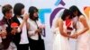 FILE - Newly married same-sex couple Tran Ngoc Diem Hang (R) and Le Thuy Linh (2nd R) share a moment during their public wedding as part of a lesbian, gay, bisexual, and transgender event on a street in Hanoi, October 27, 2013. 