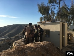 FILE - Iraqi Kurdish Peshmerga soldiers huddle around Maj. Gen. Sirwan Barzani in Makhmour, Iraq. Makhmour is expected to serve as one of the staging points for Iraqi and Peshmerga forces in the advance against the Islamic State-controlled city of Mosul, March 8, 2016.