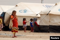 FILE - Displaced children, who fled from the Islamic State violence, gather at a refugee camp in the Makhmour area near Mosul, Iraq, June 17, 2016.