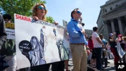 Demonstrators who gathered to protest against Islamic law take part in a rally, June 10, 2017, in New York. In more than two dozen cities across the United States, the group organizing the rallies, ACT for America, is speaking out against Shariah law, saying it is incompatible with Western democracy.