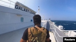 Seorang pejuang Houthi berdiri di atas kapal kargo Galaxy Leader di Laut Merah dalam foto ini yang dirilis 20 November 2023. (Media Militer Houthi via REUTERS)