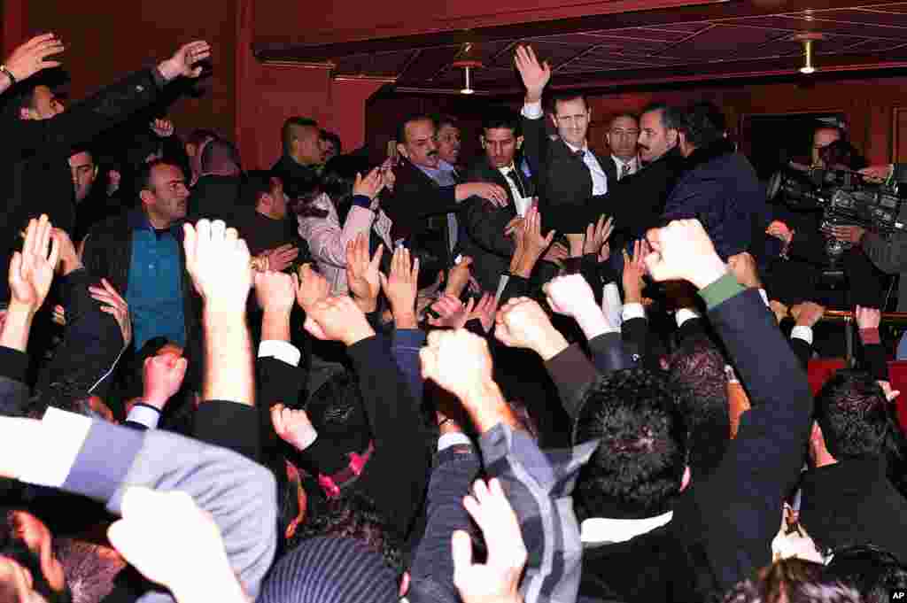 This photo released by the Syrian official news agency SANA shows Syrian President Bashar al-Assad waving to his supporters after speaking at the Opera House in central Damascus, Syria, January 6, 2013. 