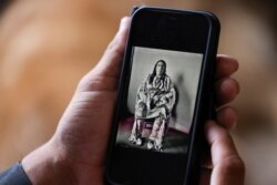 Clarence Smith, who attended Chemawa Indian School in Oregon and the Flandreau Indian School in South Dakota, looks at a photo of one of his ancestors, whom he says died in the Baker Massacre in the 1800s, in Thornton, Colorado, June 18, 2021.