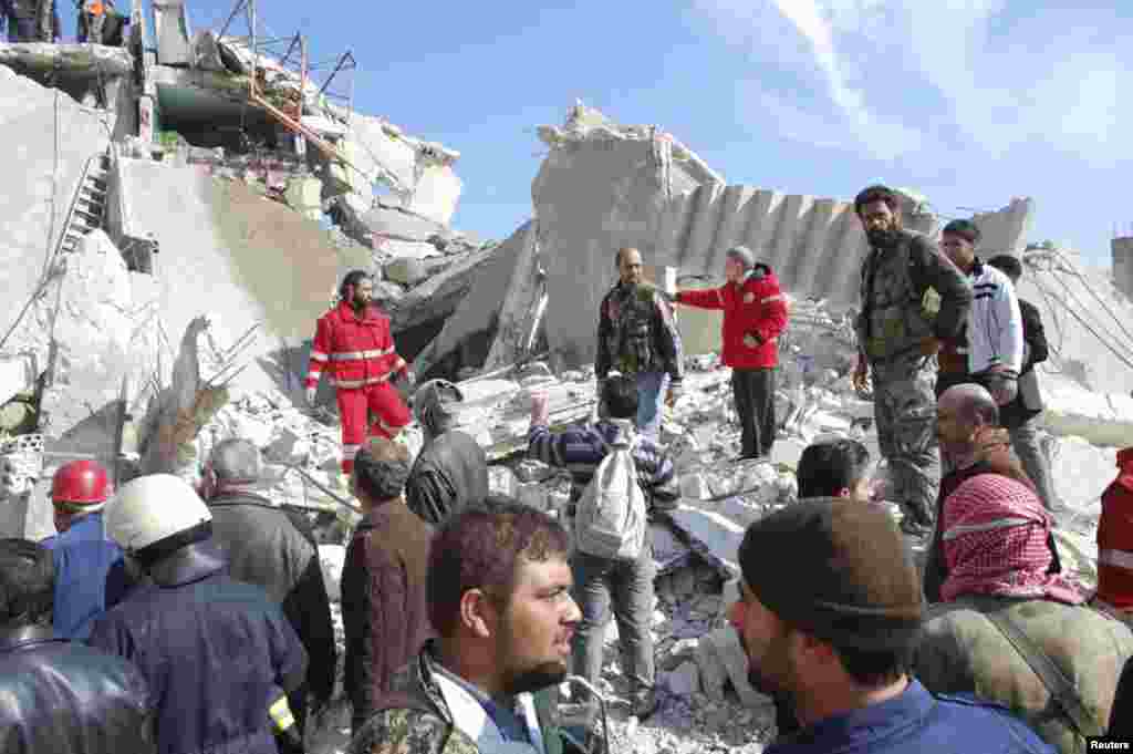 People survey the damage to a building destroyed by a suicide car bomb in Al-Kafat, Syria, &nbsp;Jan. 9, 2014.