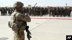 FILE - A U.S. military personal stands guard during a graduation ceremony for Afghan troops in Lashkargah, capital of southern Helmand province, Afghanistan, July 24, 2016.