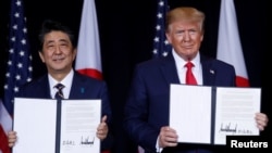 Japan's Prime Minister Shinzo Abe and U.S. President Donald Trump pose with a joint statement the two leaders made during a bilateral meeting on the sidelines of the 74th session of the United Nations General Assembly in New York City, Sept. 25, 2019.