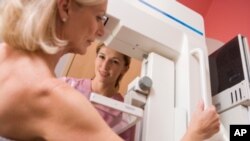 FILE - A nurse assists a patient undergoing a mammogram.