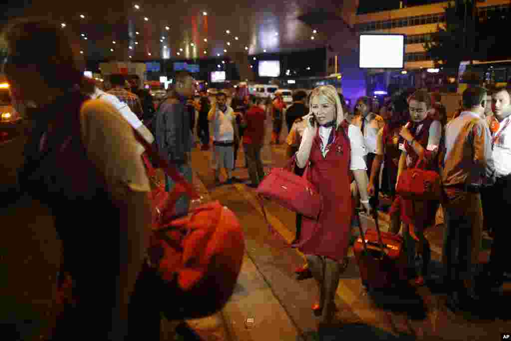 Members of a flight crew leave Istanbul's Ataturk airport in the early-morning hours of June 29, 2016. Blasts set off by suicide bombers hit the terminal, killing dozens of people and wounding many others, Turkish officials said. 