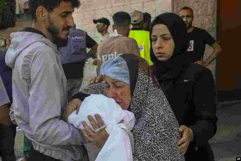 Mama wa kipalestina akibusu sanda iliyofunikwa mwili wa mtoto mdogo aliyeuliwa wakati wa shambulizi la ndege la Israel Jumapili Oktoba 15, 2023.