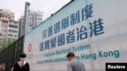 Iklan pemerintah yang mempromosikan reformasi elektoral Hong Kong terlihat sebelum pertemuan parlemen China, di Hong Kong, China 26 Maret 2021. (Foto: Reuters)