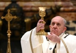 FILE - Pope Francis leads the Mass on Christmas Eve in St. Peter's Basilica amid the coronavirus disease (COVID-19) pandemic at the Vatican, Dec. 24, 2020.