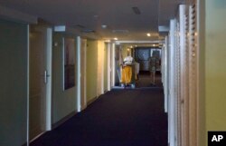 In this Sept. 12, 2017, photo, a person walks past a cleaning cart at the Hotel Capri in Havana, Cuba. Details about a string of mysterious “health attacks” on U.S. diplomats in Cuba indicate the incidents were narrowly confined within specific rooms or parts of rooms.