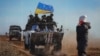 Lugansk, 23-fevral, 2022: Severodonetsk shahrida ukrain harbiylarining banneri oldidan o'tib ketayotgan ayol 