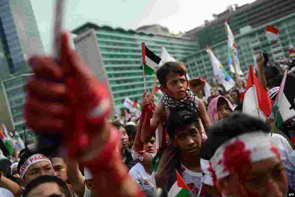 Indonesian demonstrators, some splashed with red paint, stage a huge pro-Palestinian rally in Jakarta condemning Israel&#39;s offensive in Gaza.