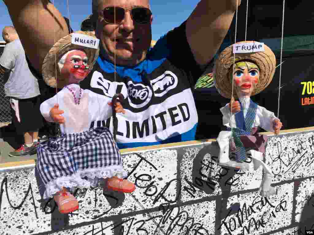 A man holds puppets representing Donald Trump and Hillary Clinton in Las Vegas, Nevada, a few kilometers from the site of the third presidential debate, Oct. 19, 2016. (J. Oni/VOA) 