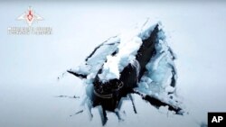 A Russian nuclear submarine breaks through the Arctic ice during military drills at an unspecified location, March 26, 2021, in this handout photo taken from a footage released by Russian Defense Ministry Press Service.