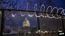 Flowers are placed along the razor wire fencing that now surrounds the U.S. Capitol on Jan. 15, 2021, in Washington.