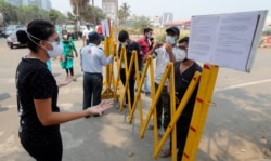 A woman argues with a doctor as she is turned back following shortage of COVID-19 vaccine at a vaccination center in Mumbai, India, Monday, May 3, 2021. (AP Photo/Rafiq Maqbool)