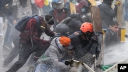 Anti-government protesters take cover from a police water cannon during clashes in Madrid, on the outskirts of Bogota, Colombia, May 28, 2021. 