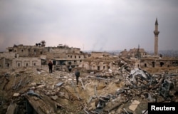 A member of forces loyal to Syria's President Bashar al-Assad stands with a civilian on the rubble of the Carlton Hotel, in the government-controlled area of Aleppo, Syria, Dec. 17, 2016.