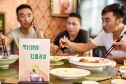 FILE - A sign encouraging people not to waste food is seen at a restaurant in Handan in China's northern Hebei province on August 13, 2020.