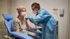 A woman receives a vaccination against the COVID-19 at a temporary vaccination center in Lodz, Poland, Jan. 25, 2021. 