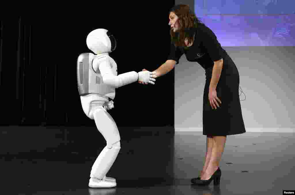 Robot manusia bikinan Honda 'Asimo' berjabat tangan sebelum presentasi di kota Zaventem, Belgia.